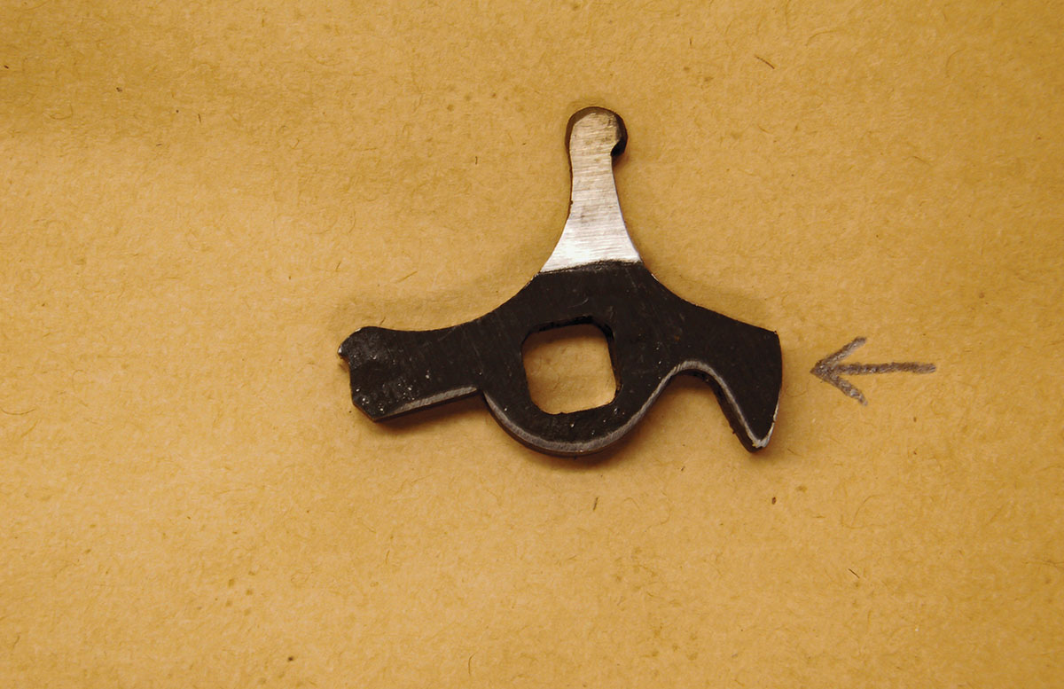 The arrow points to the third arm of the Martini cocking piece where the safety rod, if one is present, would contact.